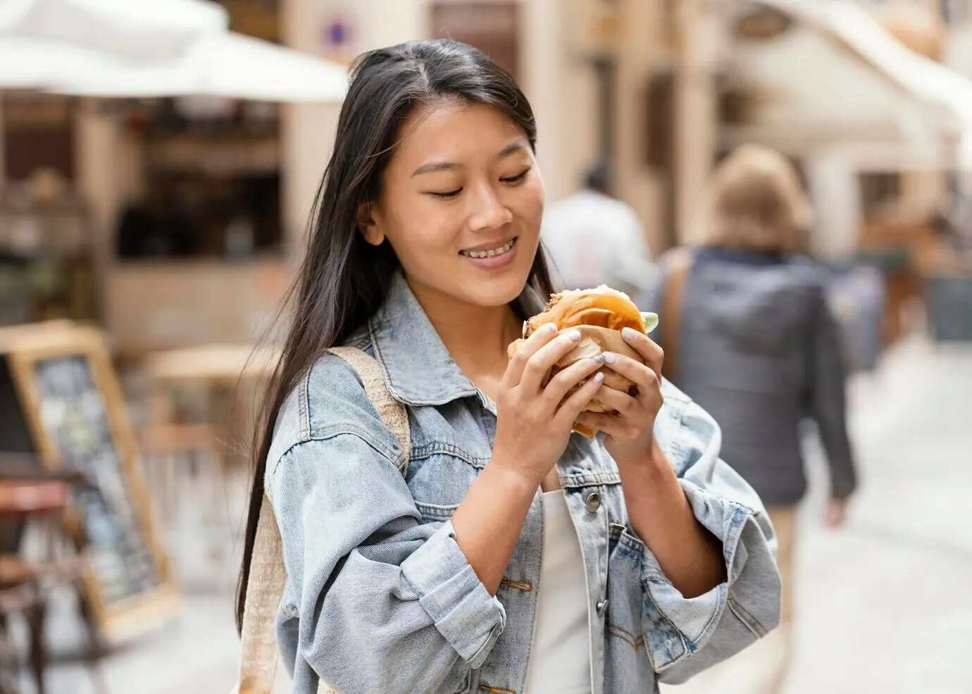 Mujer asiática feliz tras comprar comida callejera