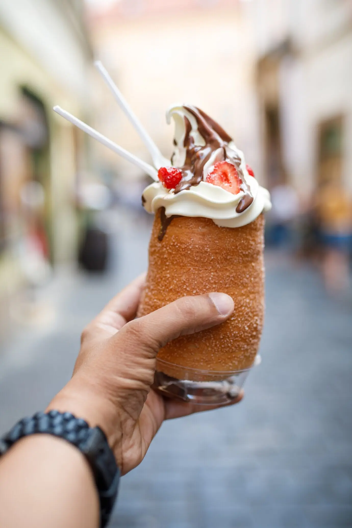 Fotografía en formato vertical de una persona que sostiene un helado de cronut en Praga, República Checa.